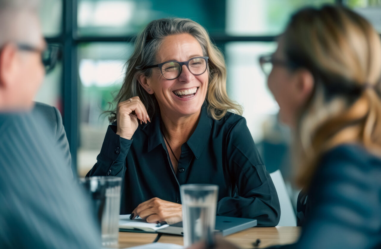 Professionals engaged in a case discussion at a bright office table with notebooks and water glasses.