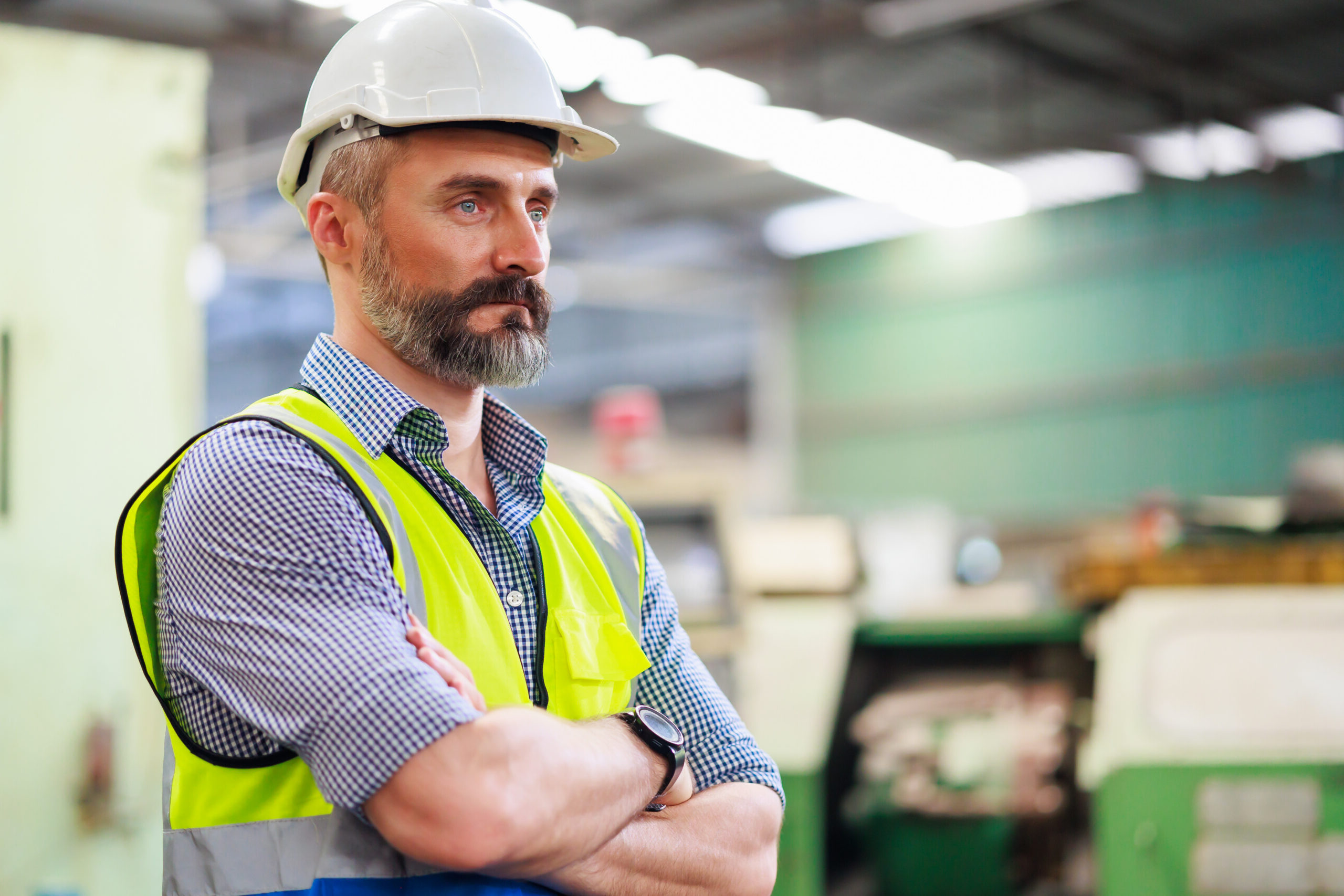 Worker in safety gear stands confidently in an industrial environment, illustrating Queensland work injury claims context.