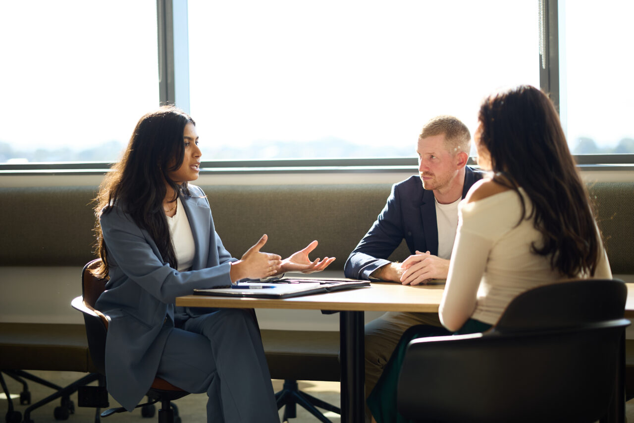 Solicitor consulting with clients at a table, demonstrating Richardson & Lyons’ expertise in personal injury law.