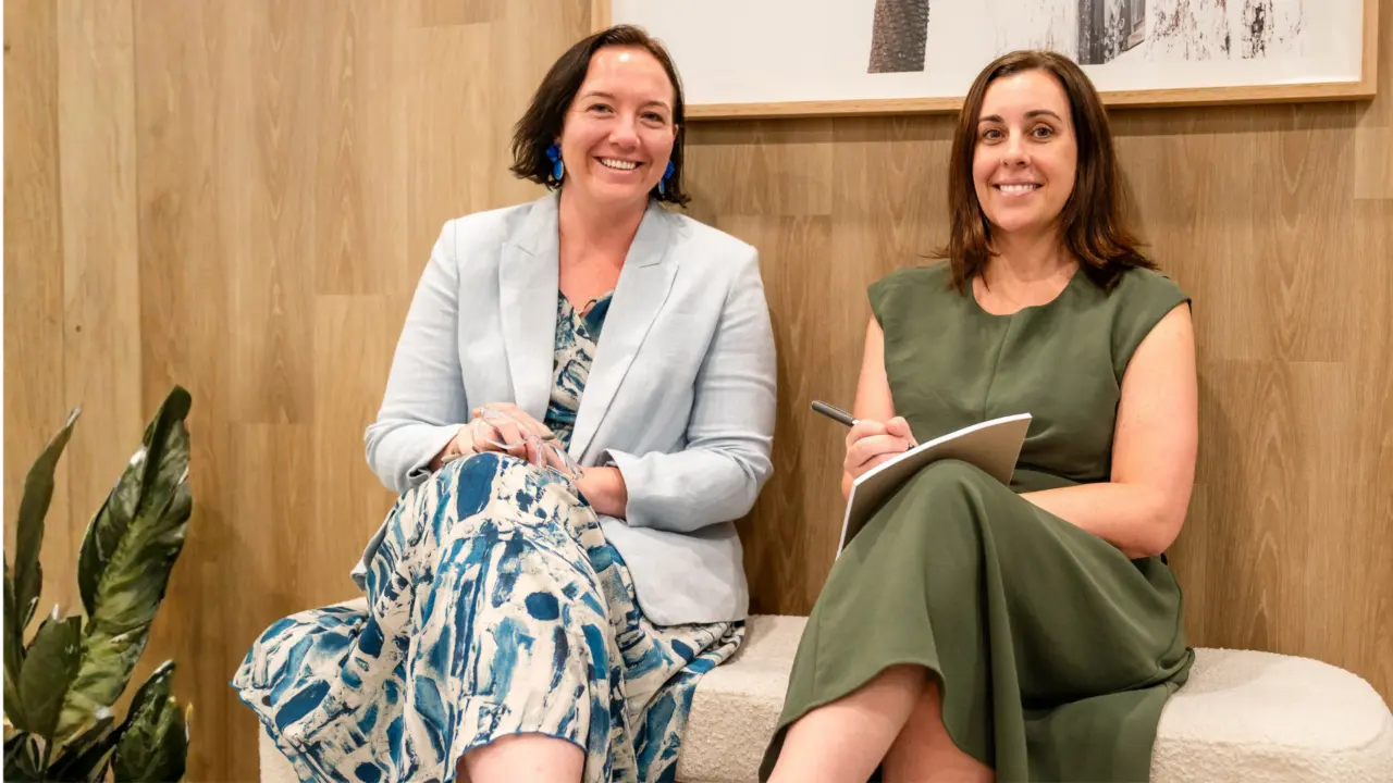 Two professionals confer on a bench in an office setting, exemplifying Richardson & Lyons’ commitment to client care.